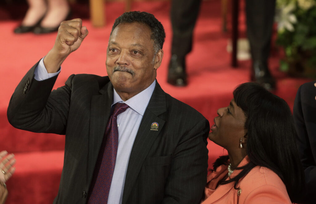 Rev. Jesse Jackson gestures to a friend in the balcony at the 16th Street Baptist Church in Birmingham, Ala., Sept. 15, 2013