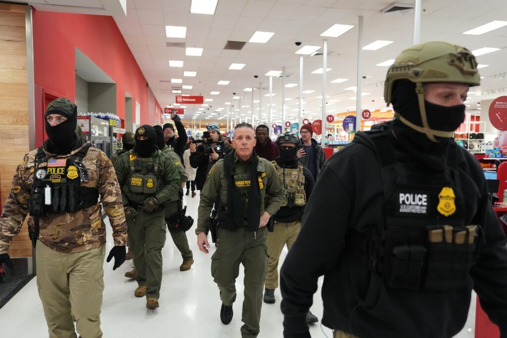 Immigration Enforcement Agency Friction FILE - U.S. Border Patrol Cmdr. Gregory Bovino walks through a Target