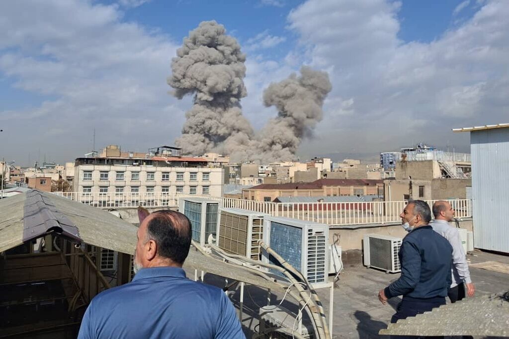 APTOPIX Iran US Israel People watch as smoke rises on the skyline after an explosion in Tehran, Iran