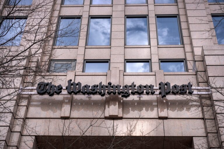 A sign above the entrance of the building for the Washington Post