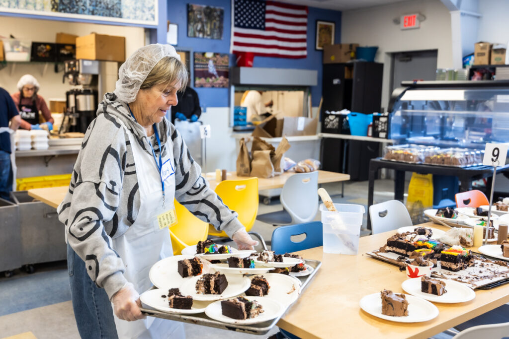 01 29 2026 k paynter trenton area soup kitcken (task) Mary Flaherty holds cake slices in the Trenton Area Soup Kitchen