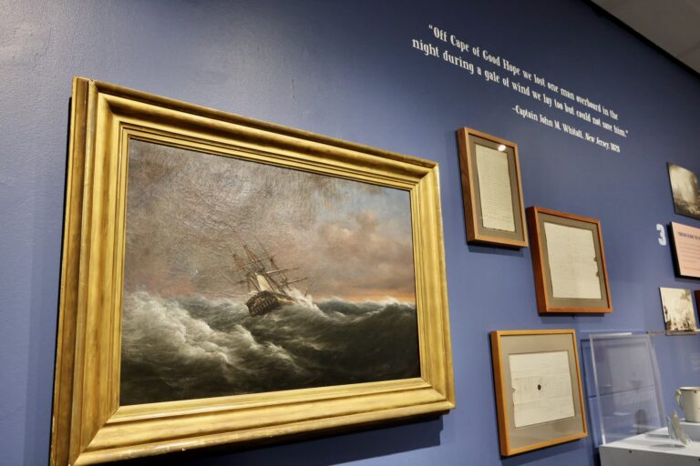 A painting hanging on the wall depicts a ship on a stormy sea.