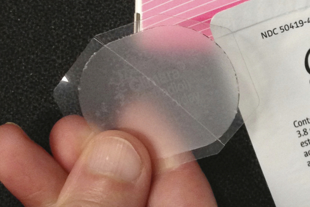 Be Well-Hormone Therapy A hand holds a low-dose estrogen skin patch
