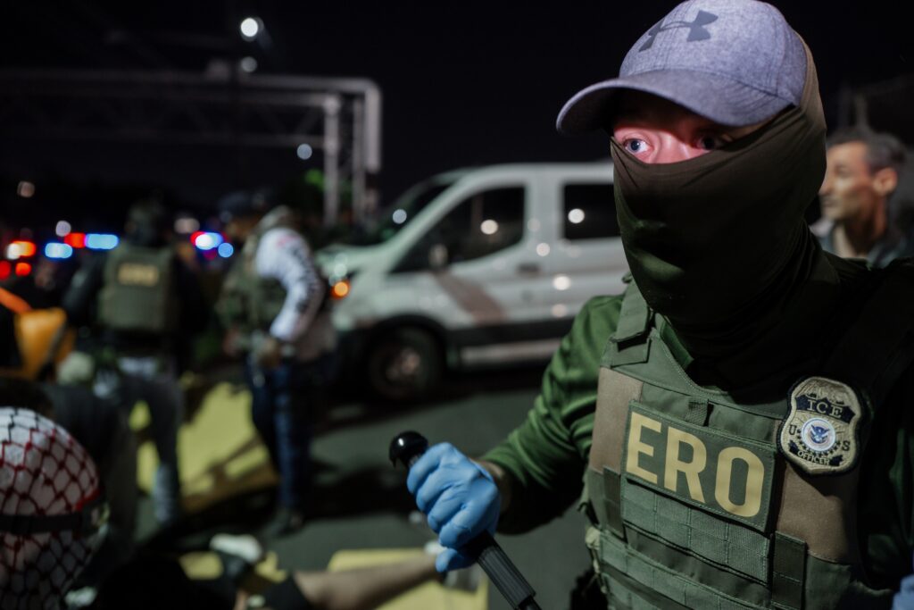 ice-agent-mask-new-jersey-2025-06-12-ap A masked Immigration and Customs Enforcement agent holds a baton