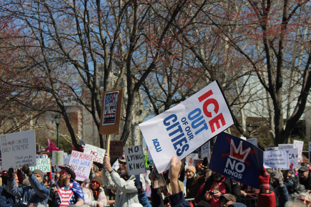 no-kings-15 People hold up signs in a protest in Philadelphia, including one that reads