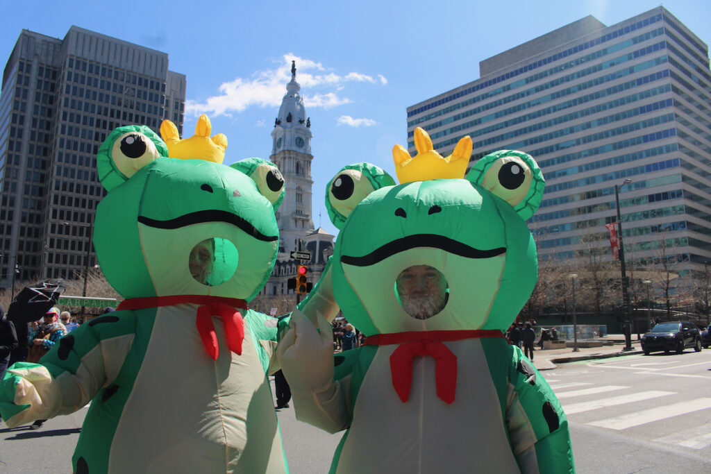 Two people dressed as frogs pose for a photo during a protest in Philadelphia against the Trump administration