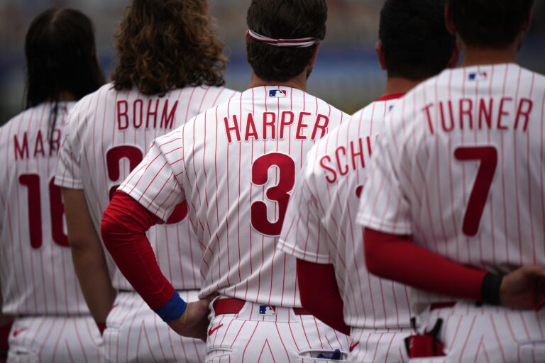 Philadelphia Phillies' Bryce Harper stands with his teammates