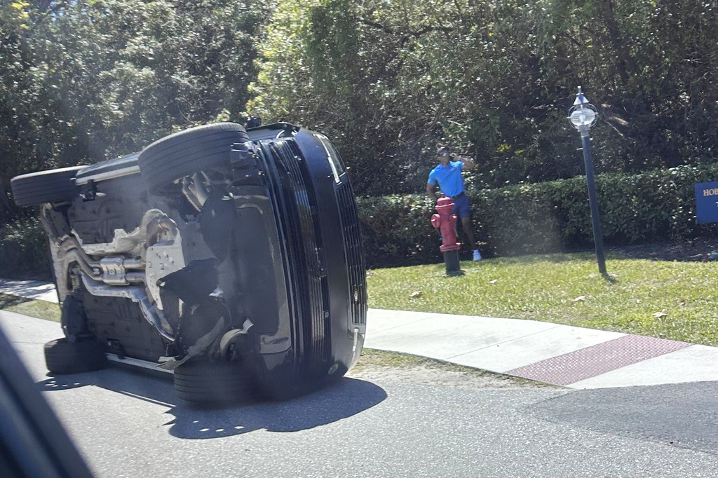 APTOPIX Tiger Woods Crash Golf Golfer Tiger Woods stands by his overturned vehicle in Jupiter Island, Florida