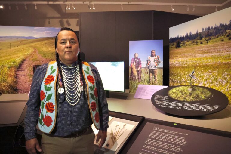Nakia Williamson-Cloud is posing for a photo inside the exhibit