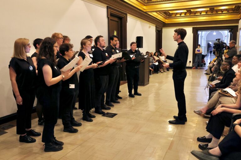 Philadelphia Voices of Pride choral ensemble performs in a hallway on the fifth floor of City Hall