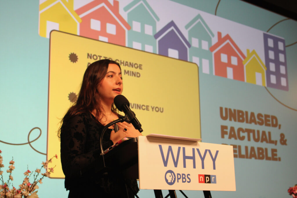 Brisa Luzzi Castro, community convener, WHYY News Community and Engagement Team, speaks into a microphone at the WHYY Civic News Summit