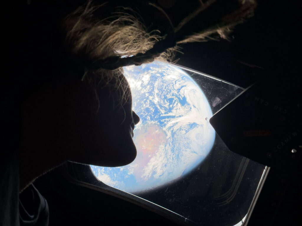 NASA Artemis Moonshot This image provided by NASA, astronaut and Artemis II mission specialist Christina Koch peers out of one of the Orion spacecraft's main cabin windows, looking back at Earth, as the crew travels towards the Moon on Thursday, April 2, 2026. (NASA via AP)