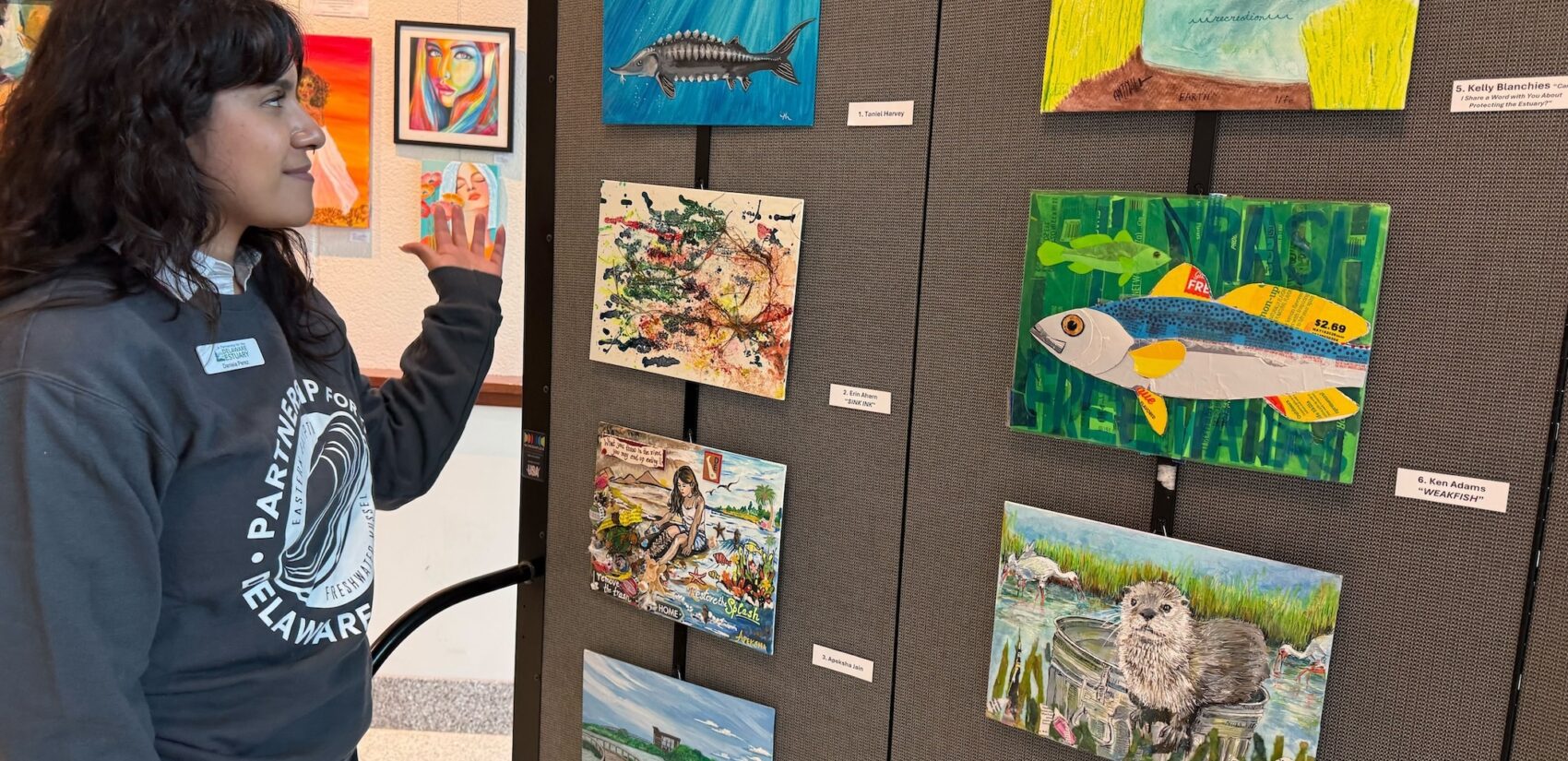 Pointing towards works of art on a wall
