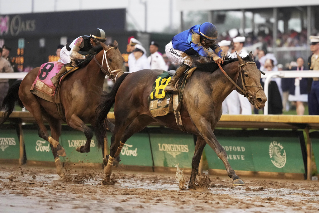 Sovereignty, right, ridden by Junior Alvarado, crosses the finish line to win the 151st running of the Kentucky Derby horse race followed by Journalism, ridden by Umberto Rispoli