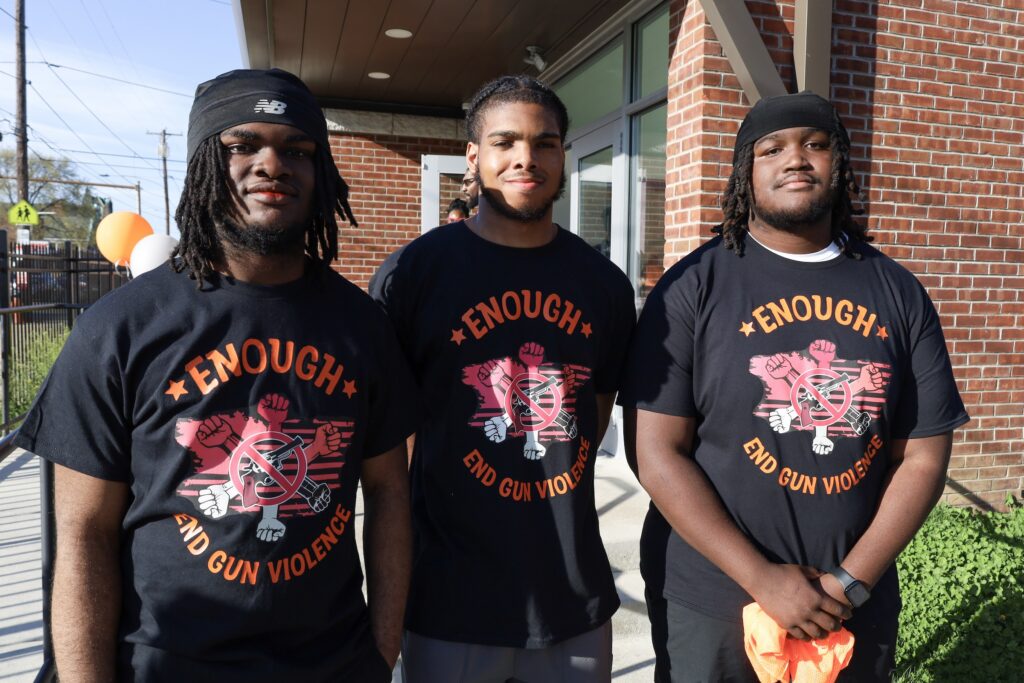 Zion Rhoden, James McClan and Kai Sample pose for a photo, and all are wearing matching anti-gun violence shirts