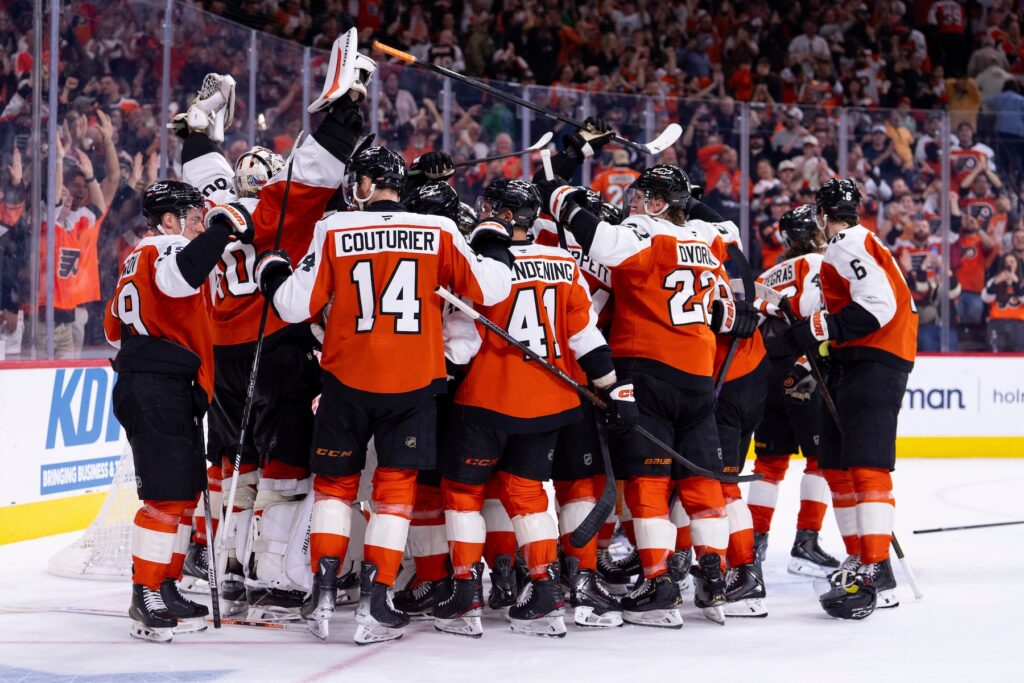 The Philadelphia Flyers gather around the net of goalie Dan Vladar