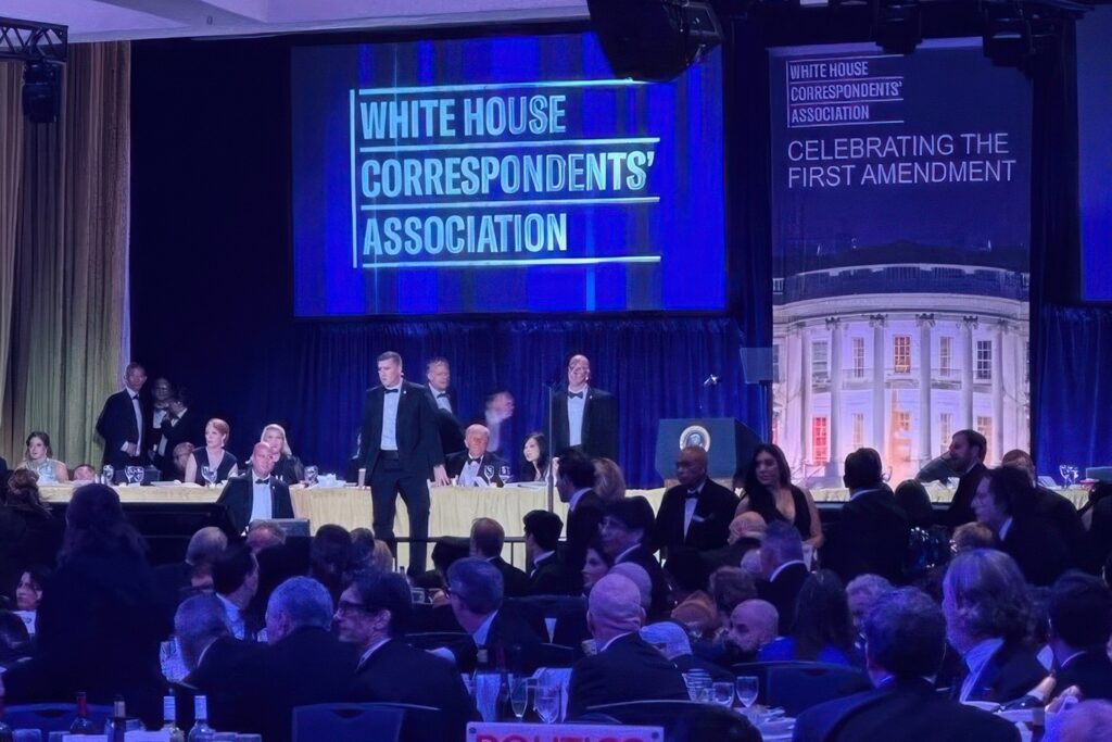 white-house-correspondents-dinner-shooting-2026-04-25-3 U.S. Secret Service agents surround President Donald Trump as he is taken from the stage after a shooting incident outside the ballroom during the White House Correspondents Dinner