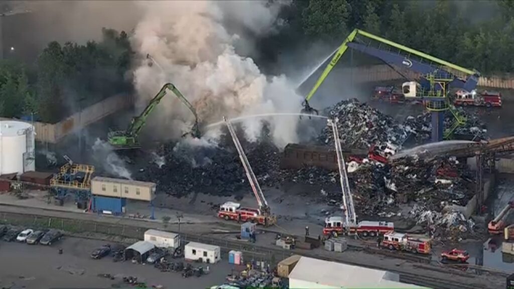 Firefighters work to put out scrap metal fire