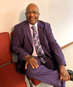 Tony Neal is sitting and posing for a photo.