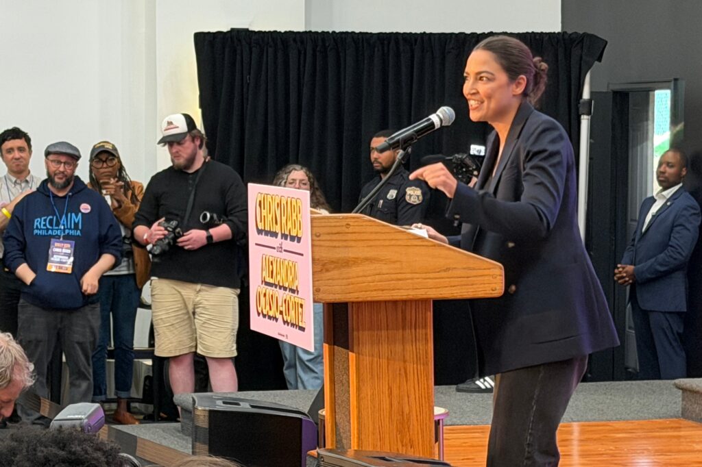 alexandria-ocasio-cortez-2026-05 Alexandria Ocasio-Cortez speaks to a crowd