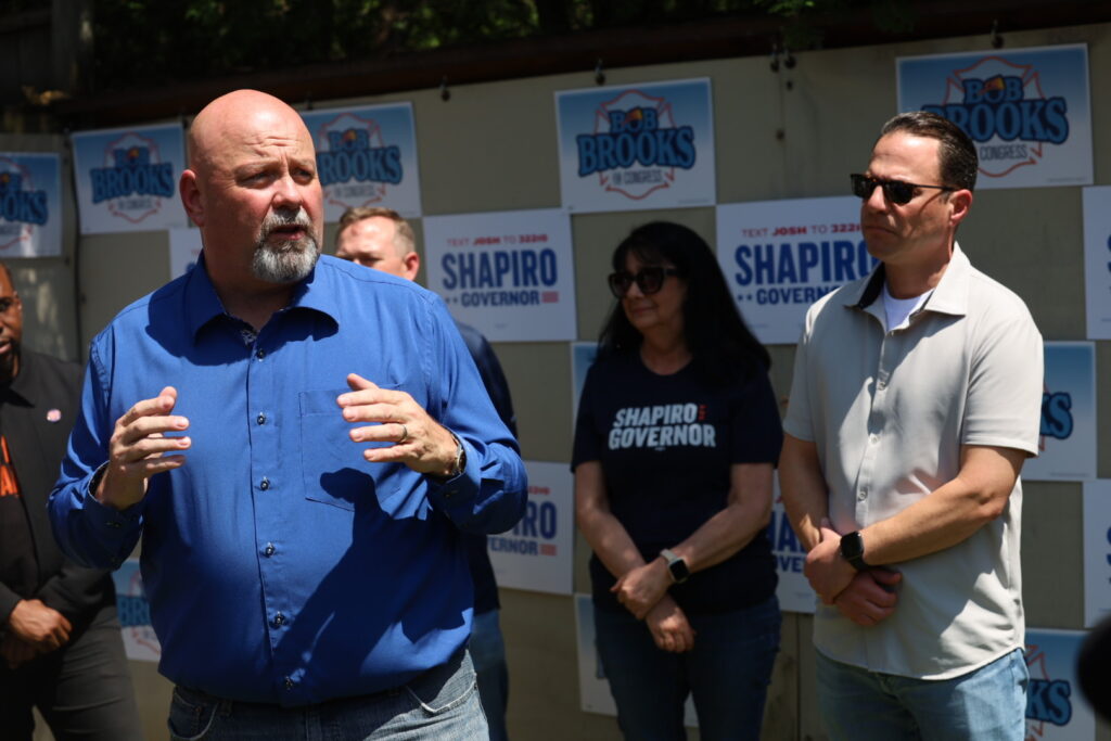 Bob Brooks, a Democratic candidate for U.S. Congress in the Lehigh Valley, speaks to supporters at a home in Emmaus as Gov. Josh Shapiro listens.