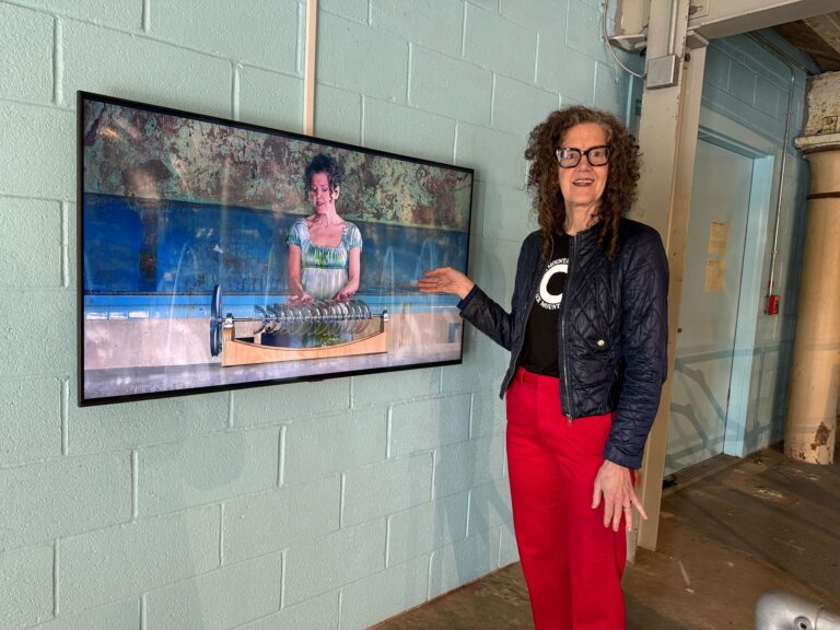 Martha McDonald watches herself on screen playing the armonica