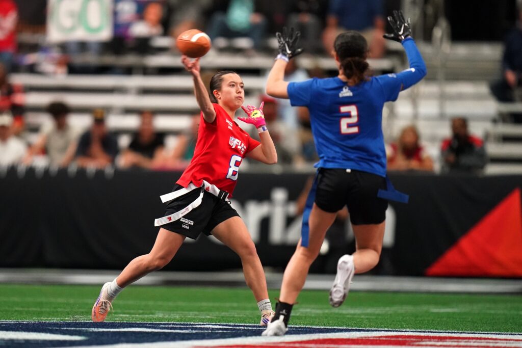 Pro Bowl Football A defender rushing the quarterback who is throwing the ball in a girls flag football game.