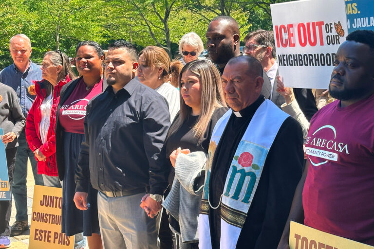 Kilmar Abrego Garcia and his wife, center, hold hands as people rally in support of him at a news conference outside federal court