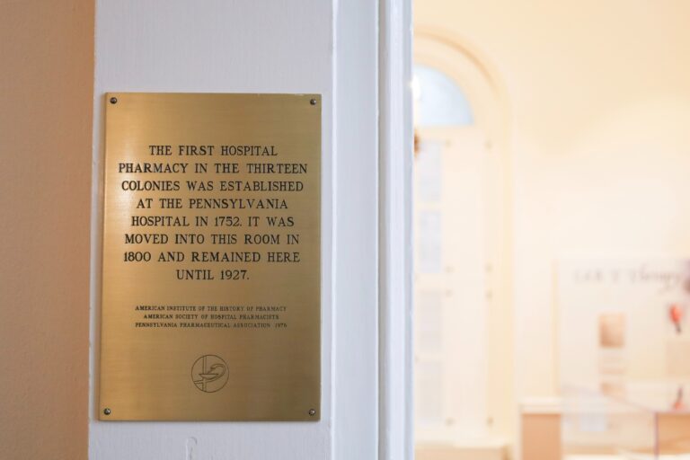 a plaque reads THE FIRST HOSPITAL PHARMACY IN THE THIRTEEN COLONIES WAS ESTABLISHED AT THE PENNSYLVANIA HOSPITAL IN 1752. IT WAS MOVED INTO THIS ROOM IN 1800 AND REMAINED HERE UNTIL 1927.