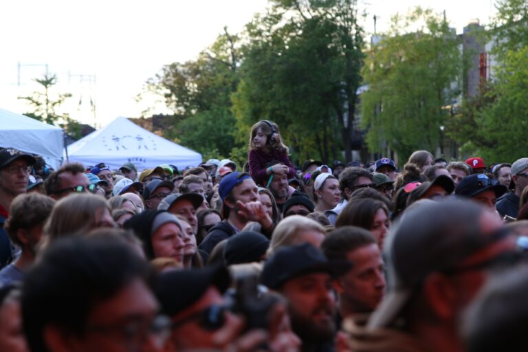Attendees standing and listening at the festival