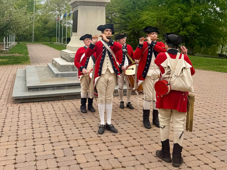 Washington Crossing Historic Park Fife and Drum Corps play their instruments while wearing 18th-century attire