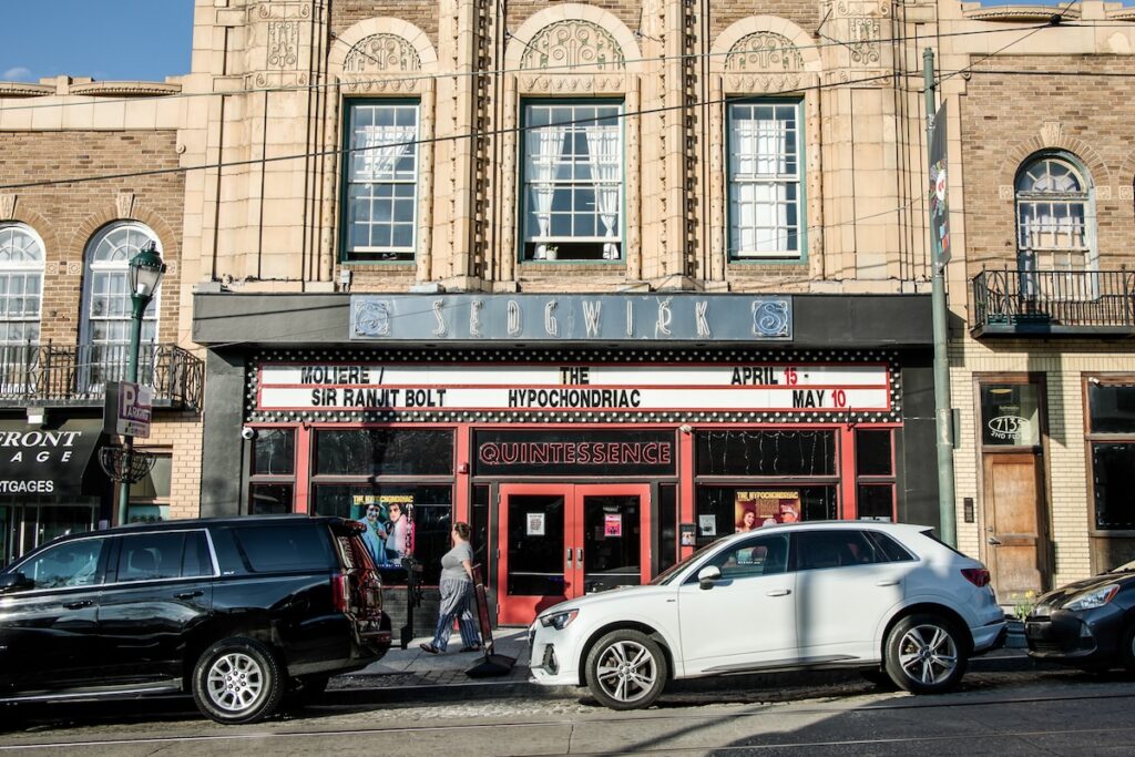 06-16-2026-k-paynter-quintessence-theatre-stills Quintessence Theatre js seen, in the middle of a busy city block.