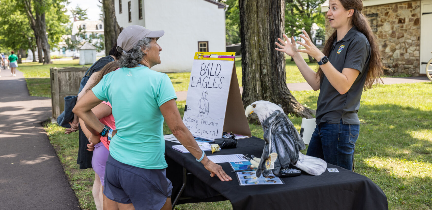 Elise Rehn speaking with someone at a booth in the park