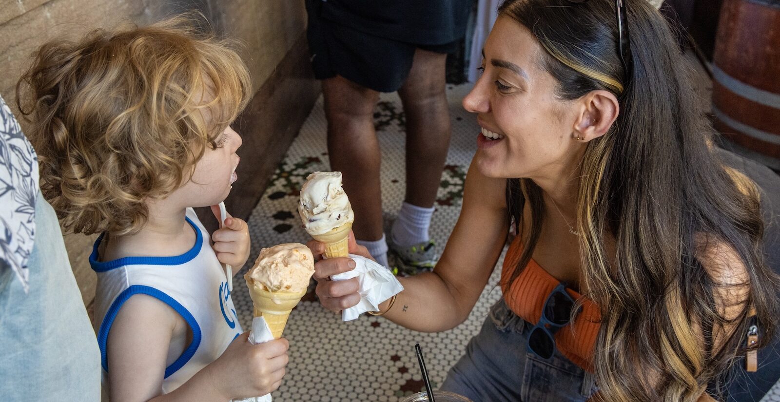 Lisa Theis and 3-year-old Henry hold up ice cream cones at Franklin Fountain in Old City, Philadelphia, amid Independence Day celebrations.