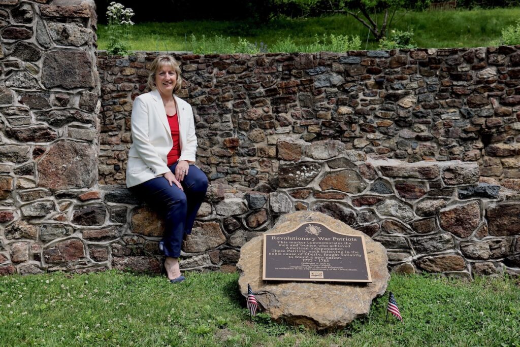 2026 05 26-e lee-karen christen-chester springs pa historic yellow springs-monument ruins revolutionary war military hospital dar marker regent Karen Christen poses for photo at ruins of American revolutionary war
