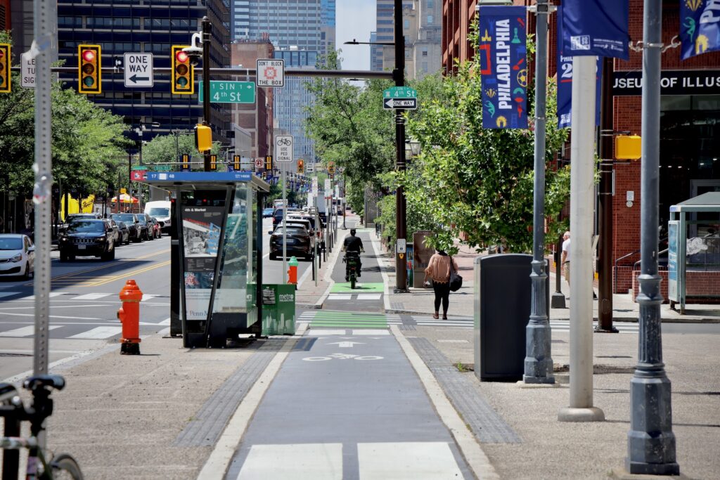 A bicyclist uses the sidewalk-level bike lane