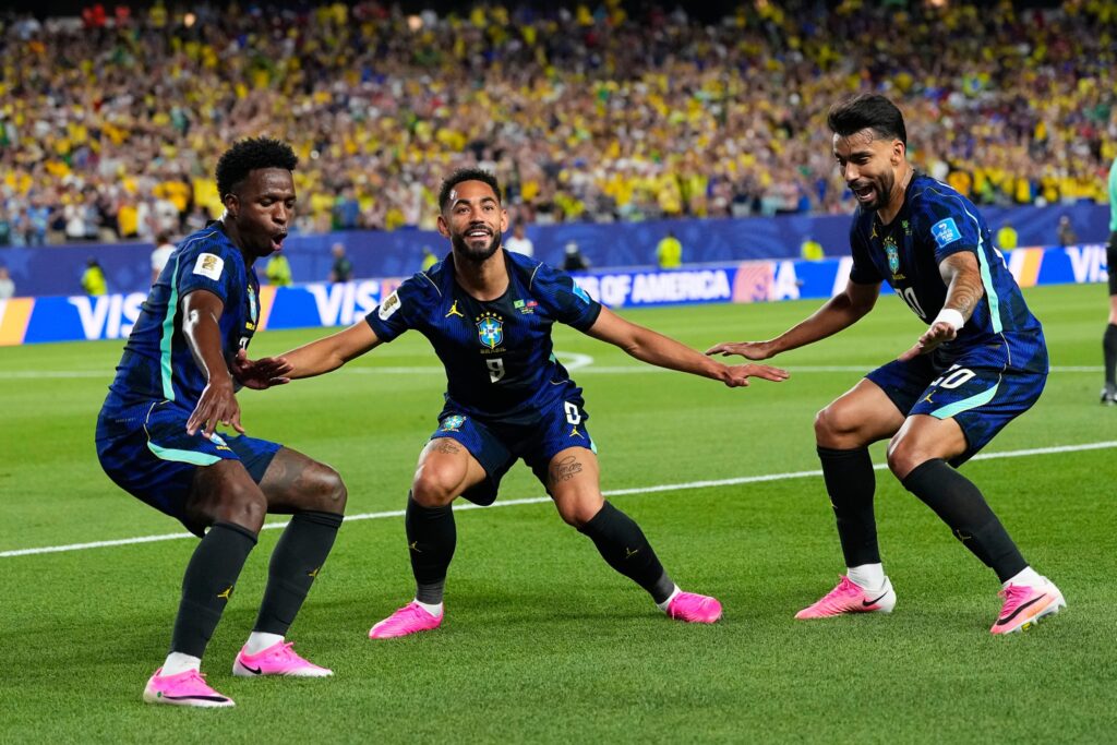 Three Brazil players celebrate after a goal.