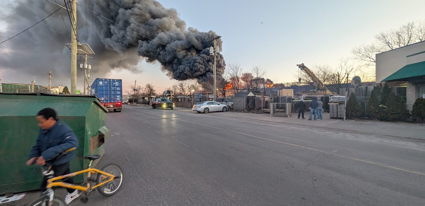 A person walks their bike away from the blaze at the EMR facility.