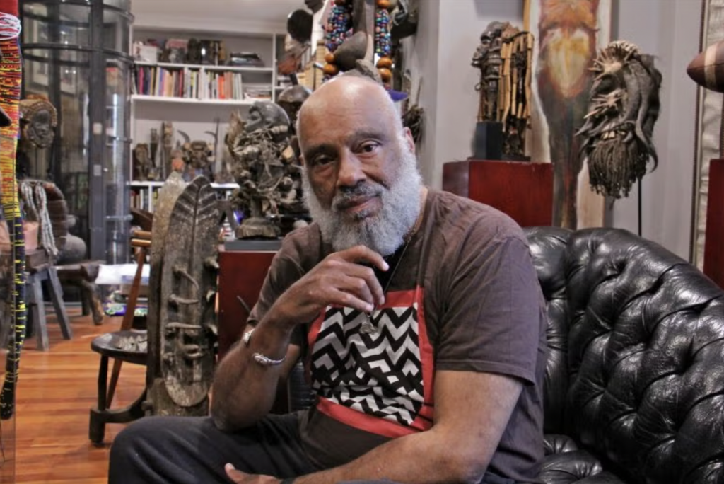 danny-simmons-e-lee-bp-2026-06-16 Danny Simmons posing for a photo surrounded by artifacts.