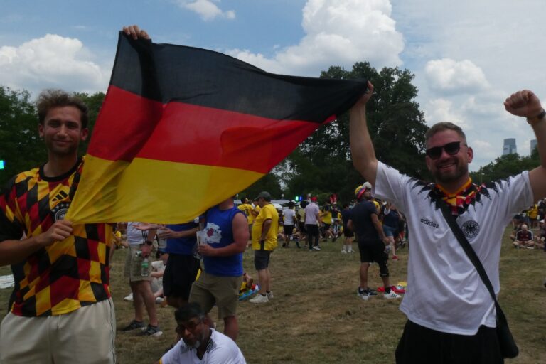 Marko Andrijanić and Marc Stoecker unfurled the German flag after the team took an early lead during their 7-1 victory over Curaçao. (Cory Sharber/WHYY)