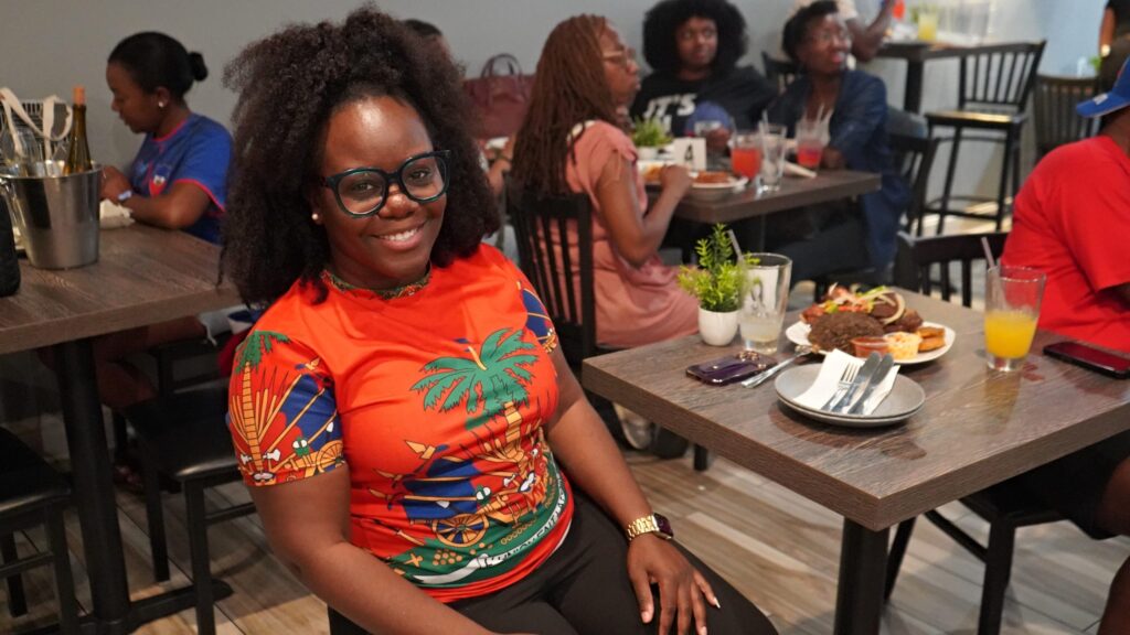 Bernice Jean-Louis poses for a photo while sitting at a table in the restaurant during the watch party.