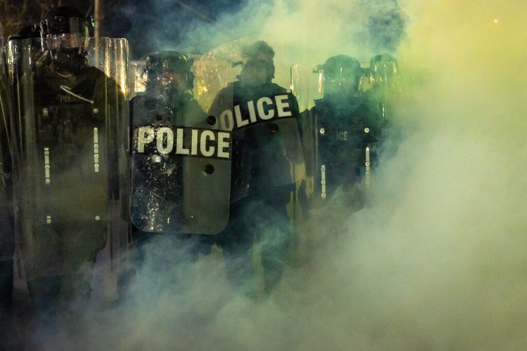 Immigration Protests New Jersey Police in riot gear are seen through the mist at the protewt