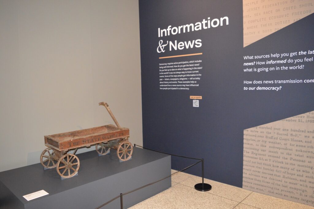 A red wagon used for delivering newspapers is on display.