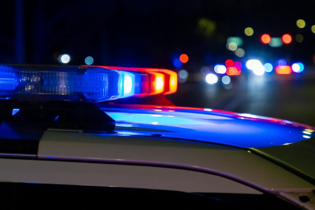 Close up of a siren on top of a police car at night.