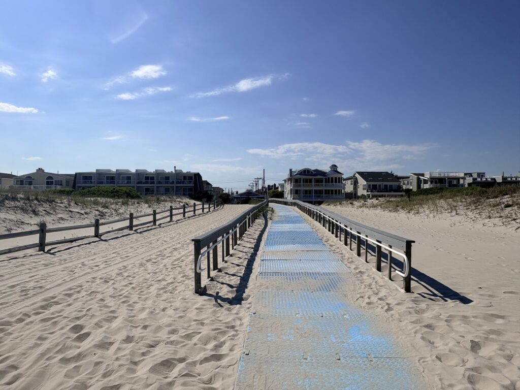 A path on the beach with mats on it.