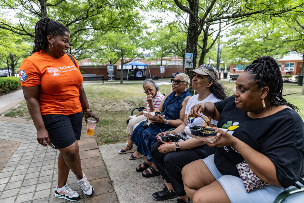 willingboro-new-jersey-whyy-barbecue-060626-13 Samantha Whitfield, the Mayor of Willingboro, (in orange) chats with Patricia Lindsay-Harvey (second from the left), the President of Willingboro Community Development Corporation and her family