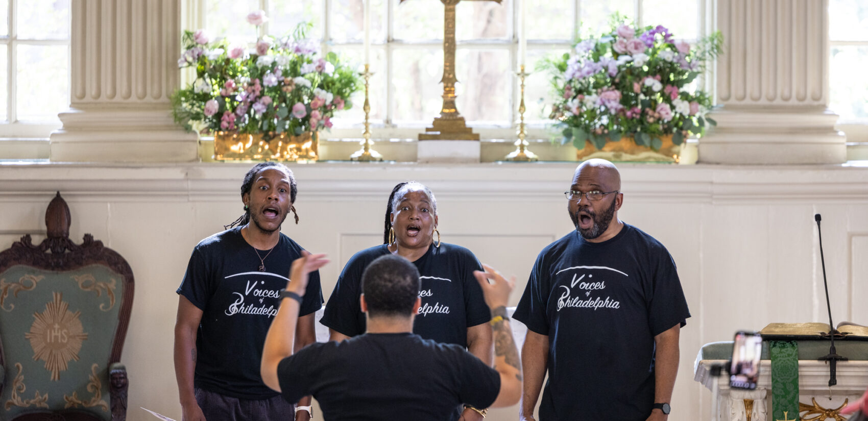 Voices of Philadelphia on stage singing at the church.