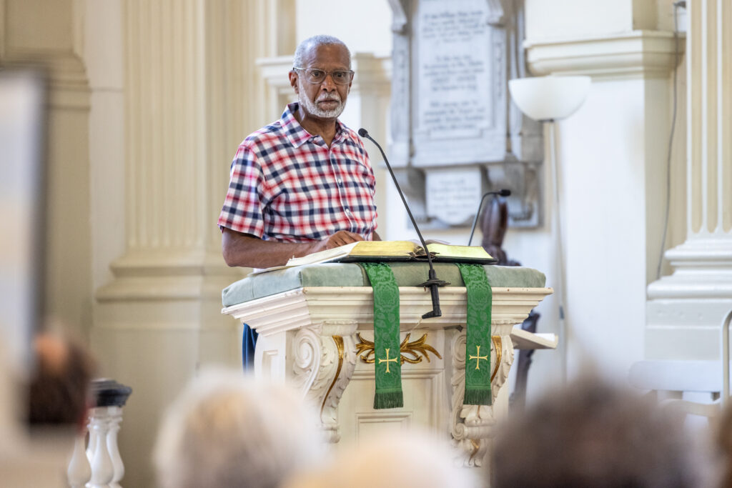State Senator Art Heywood speaking at a podium in the church.