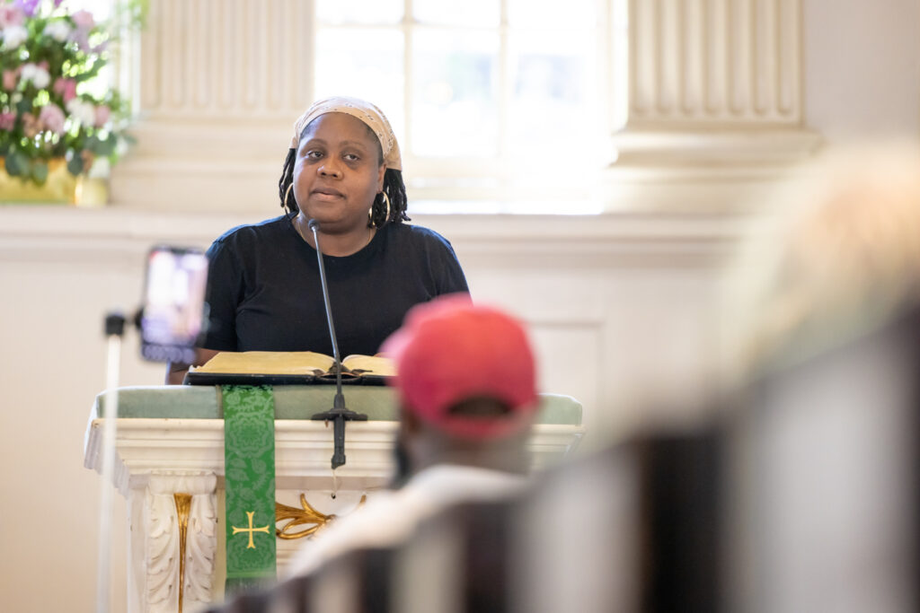 Nathalie "Talie" Cerin speaking at a podium at the church.