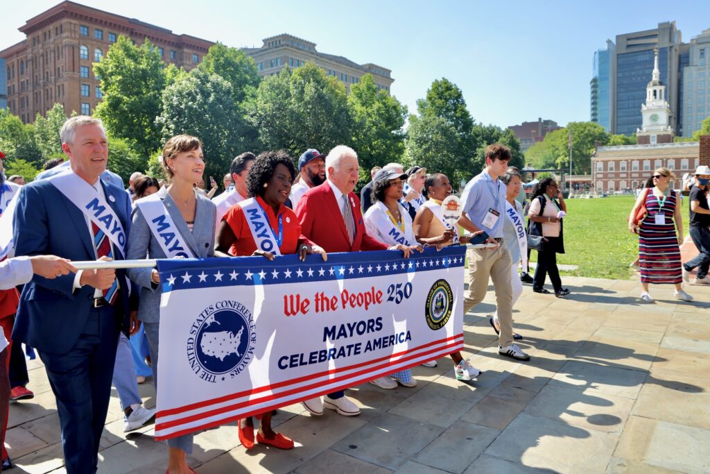 Members of the U.S. Conference of Mayors march through the city's historic district